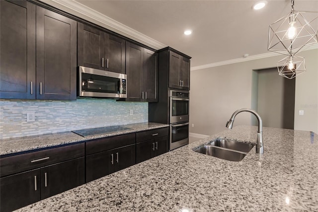 kitchen with sink, stainless steel appliances, dark brown cabinetry, light stone counters, and decorative light fixtures