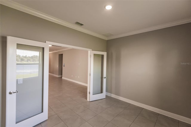 tiled spare room featuring ornamental molding and french doors