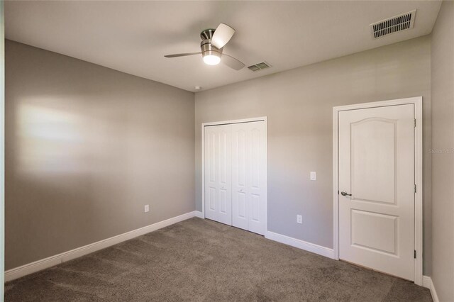 unfurnished bedroom featuring a closet, ceiling fan, and dark colored carpet