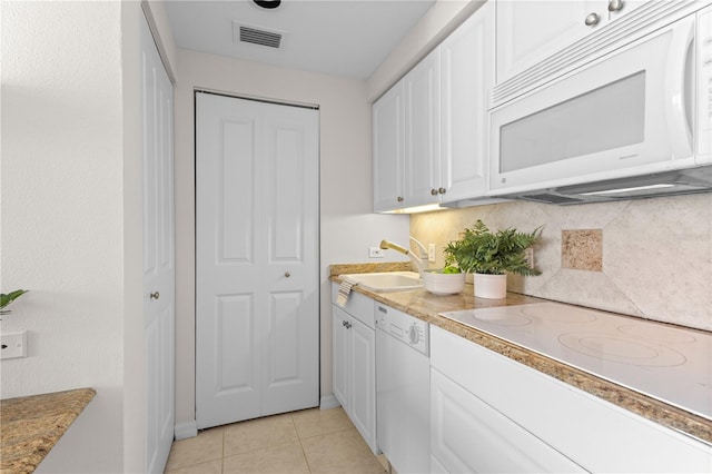 kitchen with white cabinets, light tile patterned floors, white appliances, and sink