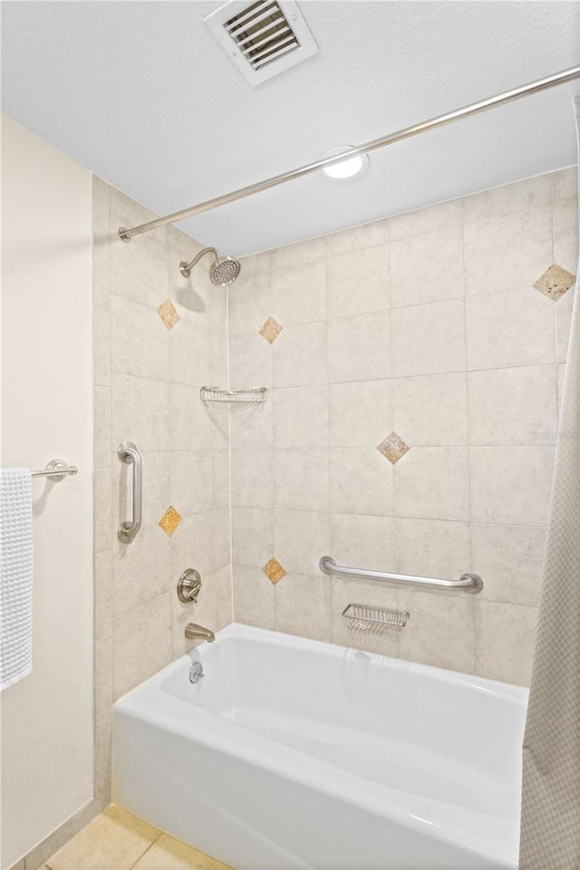 bathroom with tile patterned flooring and shower / tub combo