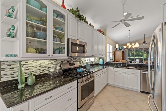 kitchen with light tile patterned flooring, backsplash, sink, appliances with stainless steel finishes, and ceiling fan with notable chandelier