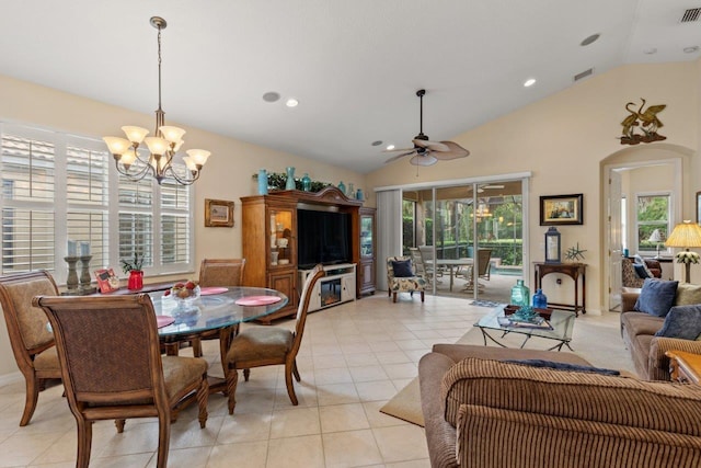 tiled dining room featuring ceiling fan with notable chandelier and vaulted ceiling