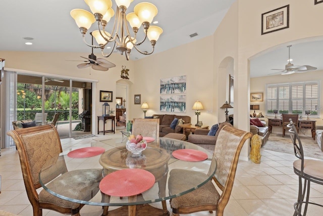 tiled dining area featuring plenty of natural light, high vaulted ceiling, and ceiling fan with notable chandelier