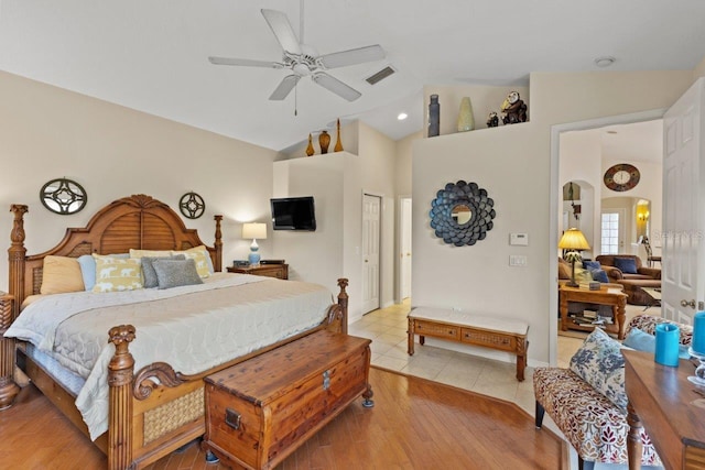 bedroom with ceiling fan, a closet, light hardwood / wood-style flooring, and lofted ceiling