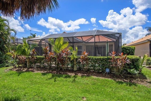 back of house featuring a lanai and a lawn