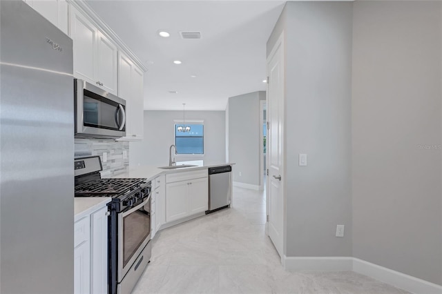 kitchen with white cabinets, backsplash, decorative light fixtures, appliances with stainless steel finishes, and sink