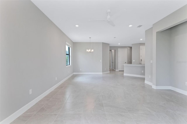 spare room with ceiling fan with notable chandelier