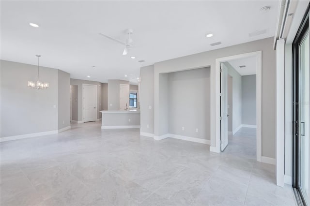 unfurnished living room featuring ceiling fan with notable chandelier and sink