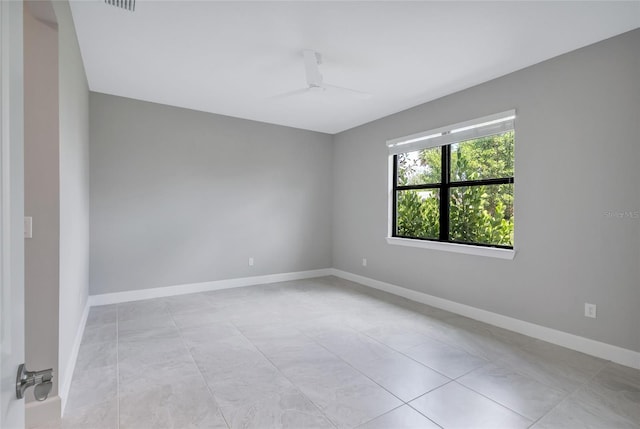 tiled spare room with ceiling fan