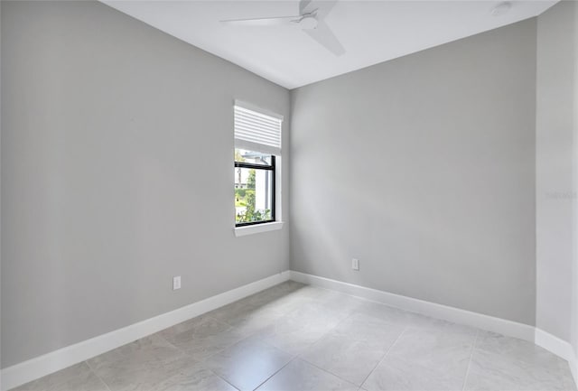 tiled empty room featuring ceiling fan