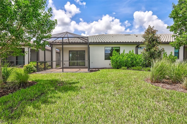 rear view of property with a lawn, a lanai, and a patio area