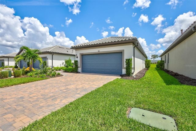 mediterranean / spanish-style home featuring a garage and a front yard