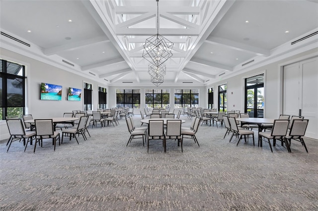 dining space featuring beam ceiling, a healthy amount of sunlight, an inviting chandelier, and carpet floors