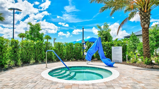 view of swimming pool featuring a hot tub