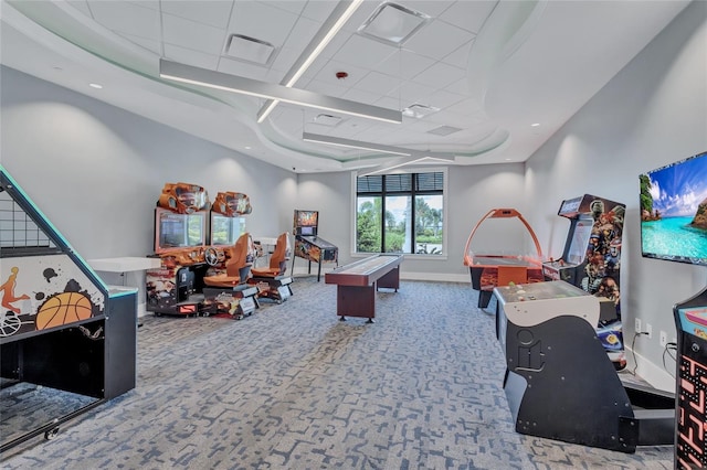 game room with a tray ceiling and carpet floors