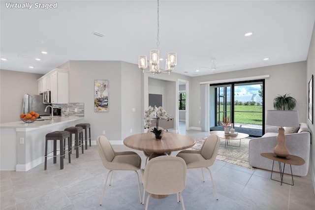 tiled dining room featuring a notable chandelier and sink