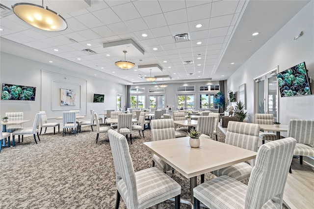 dining room with a tray ceiling and light colored carpet