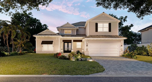 view of front of house featuring french doors, a yard, and a garage