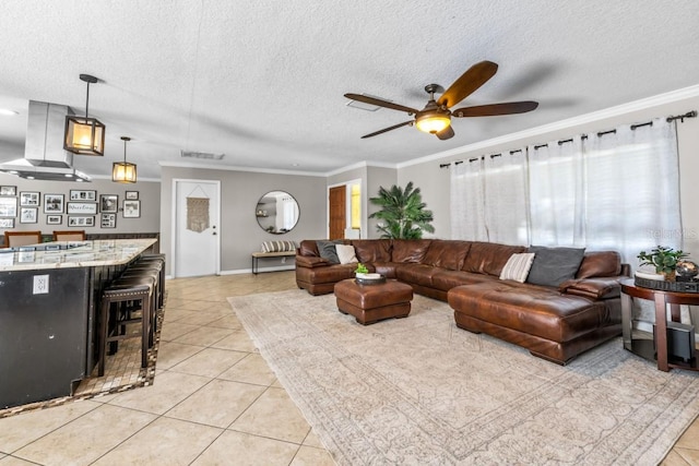 tiled living room featuring ceiling fan, crown molding, and a textured ceiling