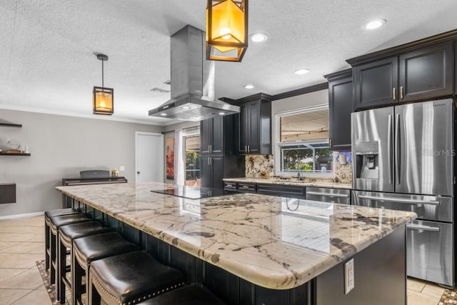 kitchen with backsplash, a center island, decorative light fixtures, appliances with stainless steel finishes, and island exhaust hood