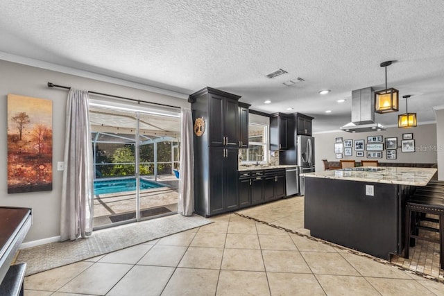 kitchen with island exhaust hood, a breakfast bar area, light stone counters, and light tile patterned flooring