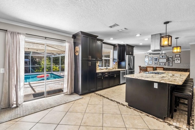 kitchen with ventilation hood, a breakfast bar, light tile patterned floors, decorative light fixtures, and crown molding