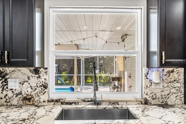 kitchen featuring sink and light stone countertops