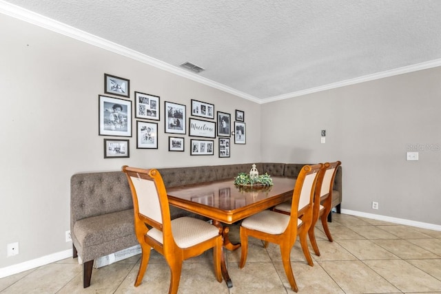 tiled dining space featuring a textured ceiling and ornamental molding