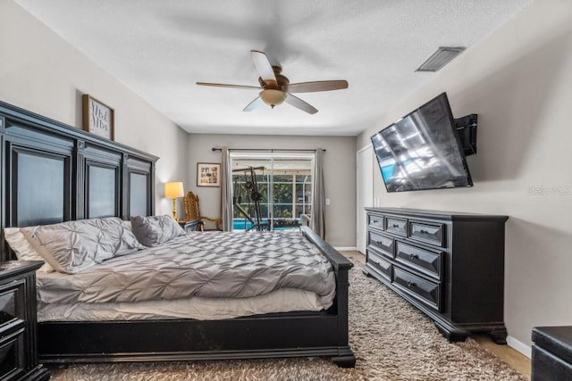 bedroom with ceiling fan, access to outside, a textured ceiling, and carpet flooring