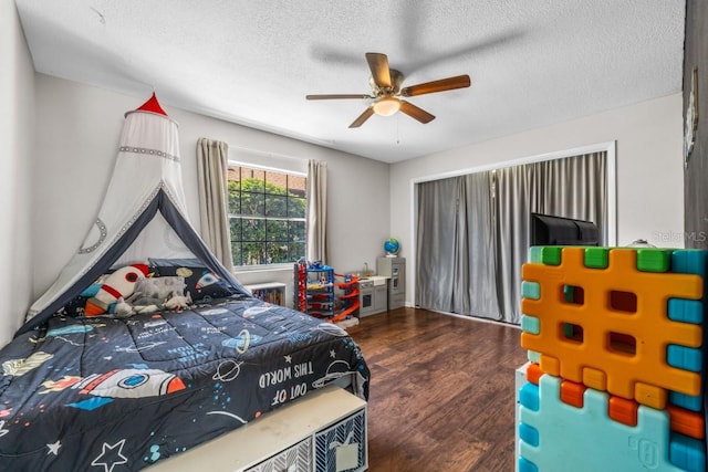 bedroom featuring ceiling fan, dark wood-type flooring, and a textured ceiling