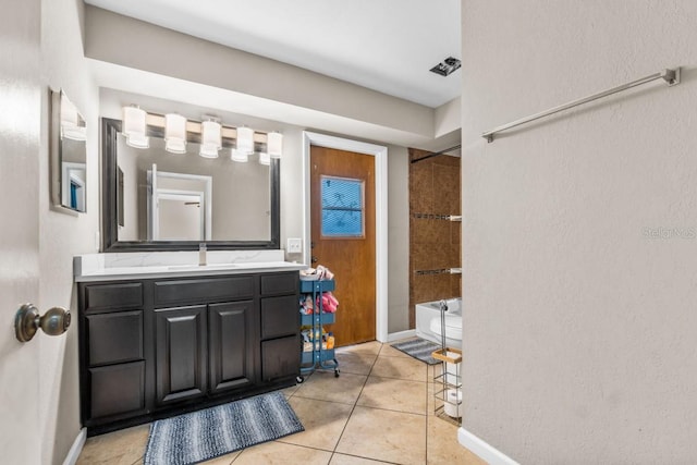 bathroom featuring tiled shower / bath combo, vanity, and tile patterned floors