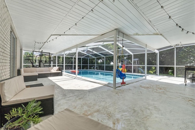 view of swimming pool featuring glass enclosure, an outdoor hangout area, and a patio