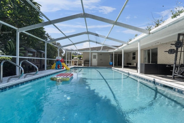 view of swimming pool with glass enclosure and a patio