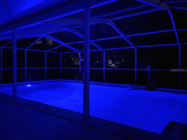 view of swimming pool featuring glass enclosure