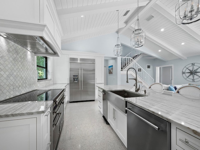 kitchen with white cabinets, light stone counters, stainless steel appliances, and beam ceiling