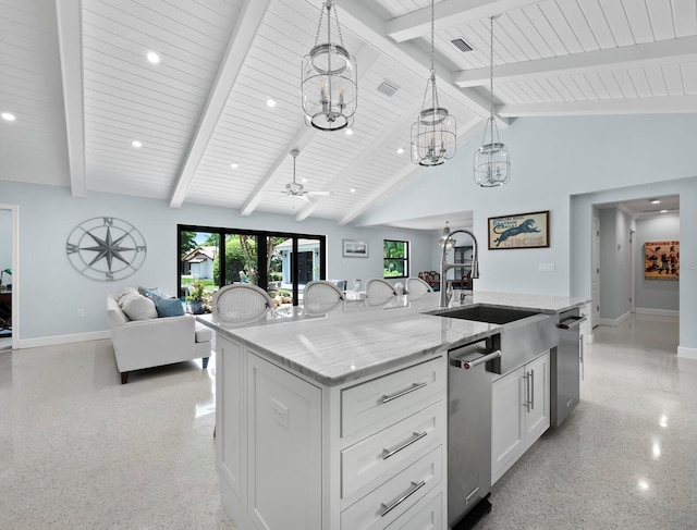 1400 Quail Dr, Sarasota, FL 34231 - kitchen with light speckled floor, open floor plan, white cabinets, and an island with sink