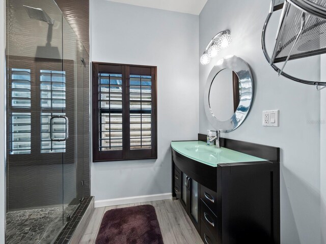 bathroom featuring vanity, hardwood / wood-style flooring, and a shower with shower door