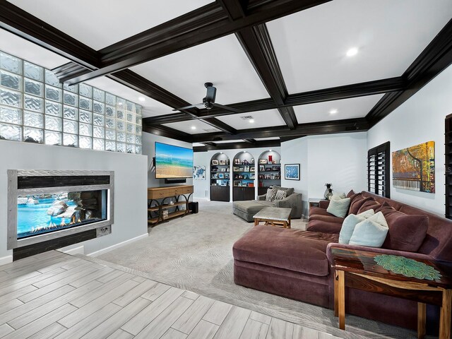 living room featuring coffered ceiling, ceiling fan, beam ceiling, and light hardwood / wood-style flooring