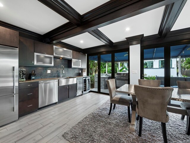 kitchen with backsplash, appliances with stainless steel finishes, sink, coffered ceiling, and dark brown cabinetry