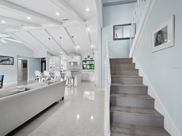 staircase featuring high vaulted ceiling, beamed ceiling, and ceiling fan