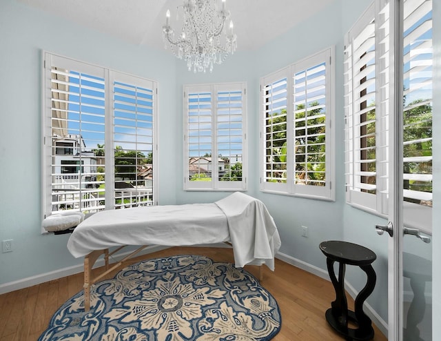 1400 Quail Dr, Sarasota, FL 34231 - bedroom with a chandelier, baseboards, and wood finished floors