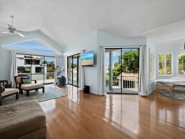 living room with lofted ceiling, hardwood / wood-style floors, and ceiling fan