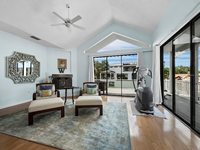 1400 Quail Dr, Sarasota, FL 34231 - sitting room with a warm lit fireplace, wood finished floors, visible vents, baseboards, and vaulted ceiling