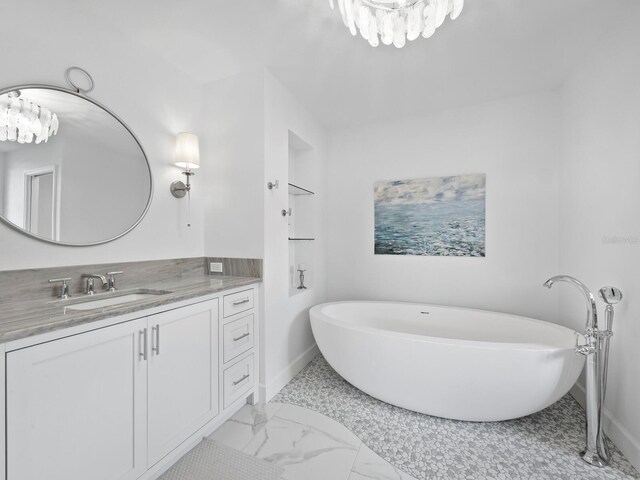 bathroom featuring a tub to relax in, vanity, and tile patterned flooring