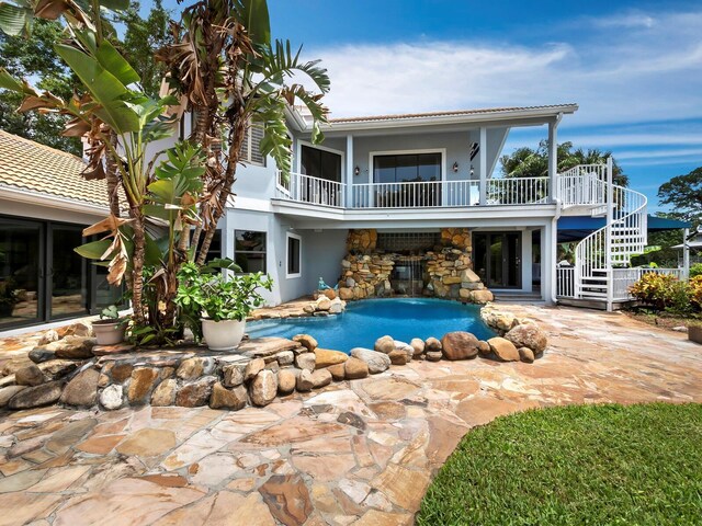 1400 Quail Dr, Sarasota, FL 34231 - back of property with a patio, a balcony, an outdoor pool, stairs, and stucco siding