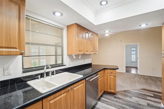 kitchen with dishwasher, ornamental molding, sink, dark stone countertops, and light wood-type flooring