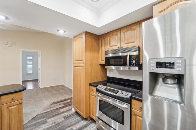 kitchen featuring ornamental molding, hardwood / wood-style flooring, and stainless steel appliances