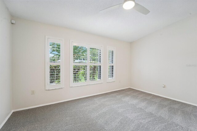 empty room with a textured ceiling, ceiling fan, and carpet