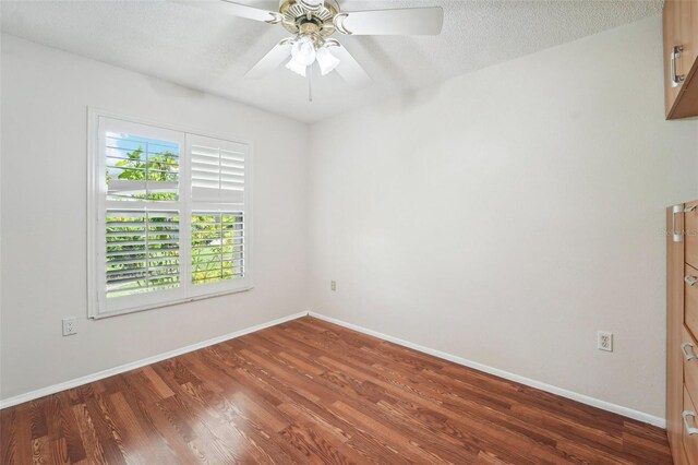 unfurnished room featuring a textured ceiling, ceiling fan, and dark hardwood / wood-style flooring